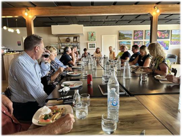 People sitting around a table eating and drinking at the Tumbarumba Roundtable